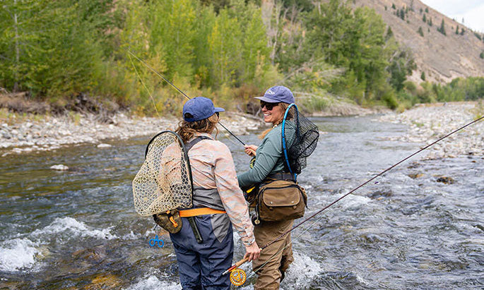 Two girls fishing on a river